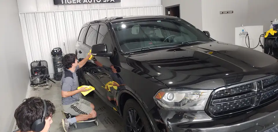 Tiger Auto Spa team working on a black Dodge Durango inside the Broken Arrow shop
